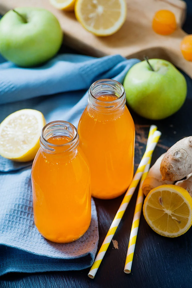 turmeric drink on table with straws and lemons