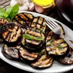 grilled eggplant on plate with olive oil dressing