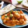 butter chicken served on a blue plate