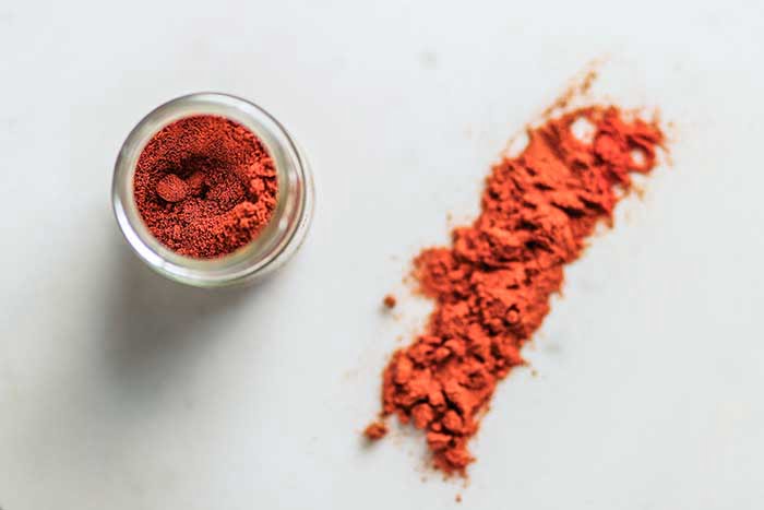 closeup of ground cayenne pepper powder on white cooking surface