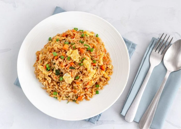 fried rice served on white plate with knife and fork