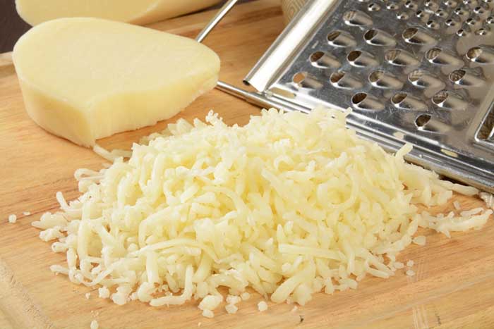 shreded mozzarella cheese on wooden cutting board