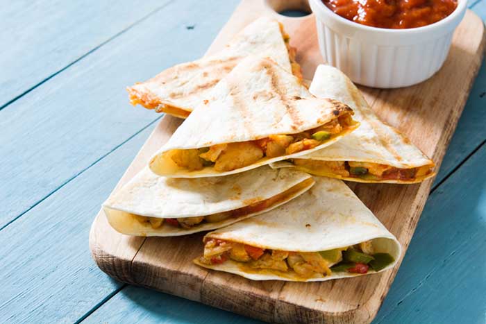 cheese quesadillas served on wooden chopping board