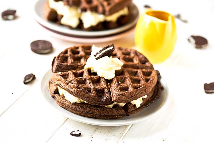 oreo waffles made from chocolate cookie batter and topped with whipped cream