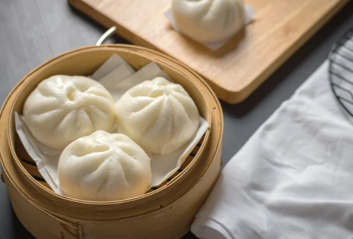 steamed chinese bao buns resting in bamboo baozi steamer