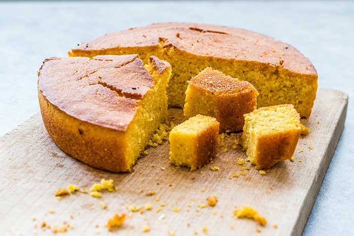 homemade cornbread on chopping board cut into small chunks ready to serve