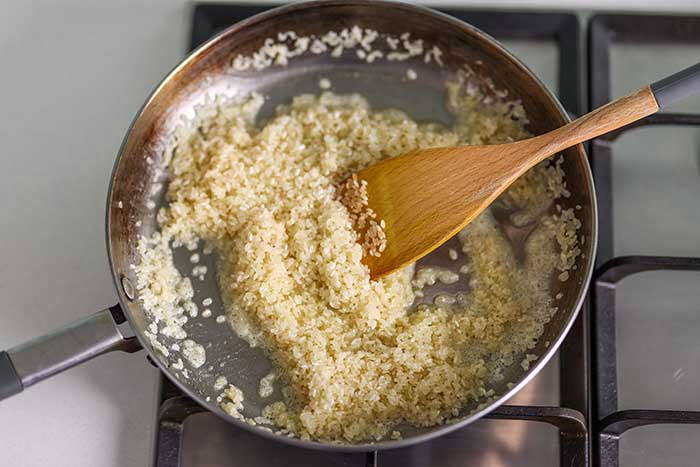 sauteeing rice and onion in iron pan