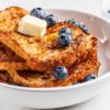 keto french toast with blueberries and low-sugar honey on a white plate