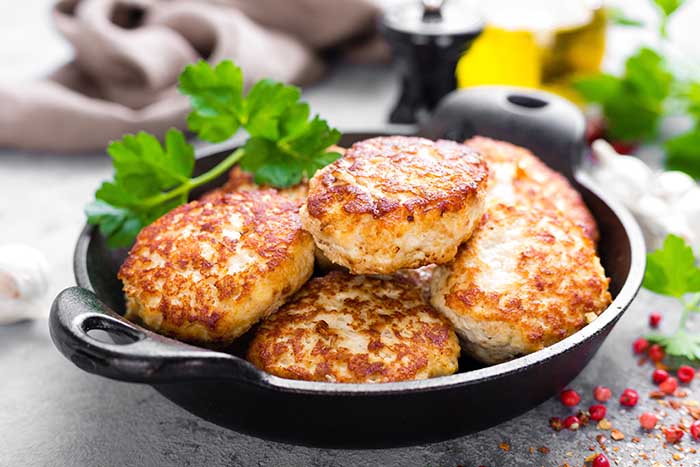 pan fried fish cutlets in black serving dish