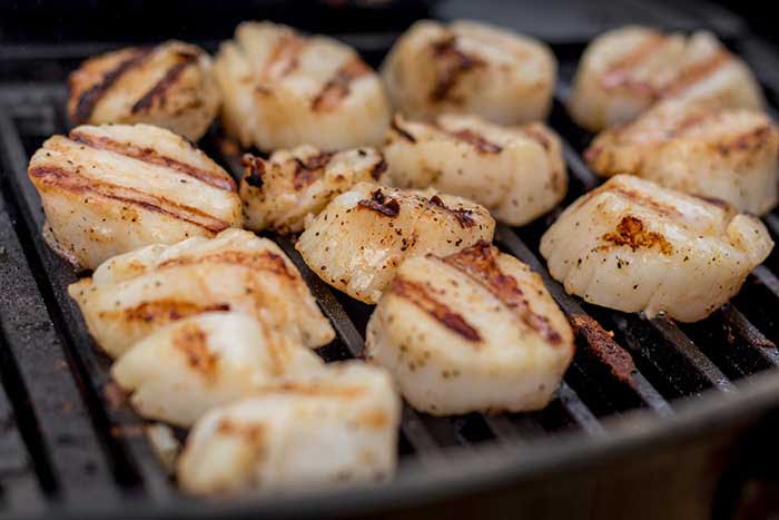 sizzling sea scallops grilling on a charcoal grill