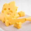 swiss cheese in a cutting board