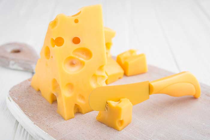 swiss cheese in a cutting board