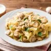 tagliatelle pasta with mushrooms, parsley and Parmesan cheese on wooden table